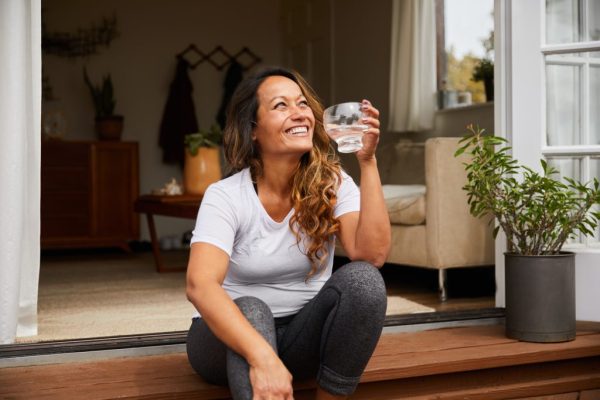 Mature woman relaxing outdoors with a glass of water