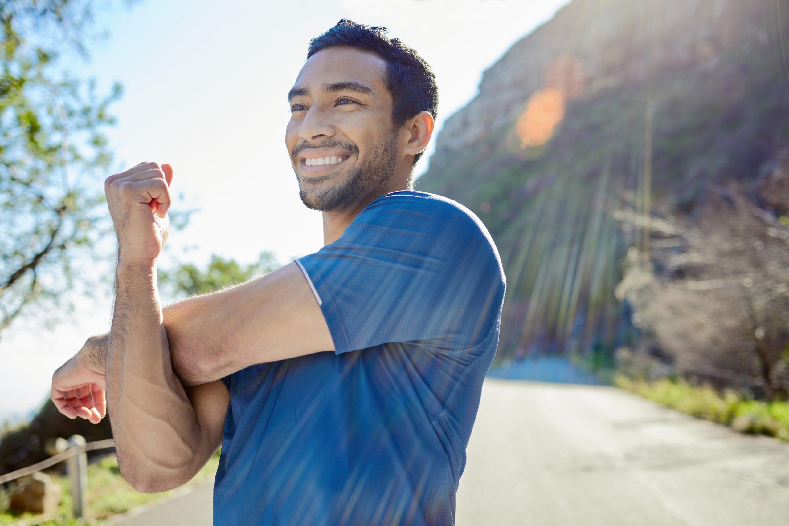 Healthy young man smiling outdoors near the mountains