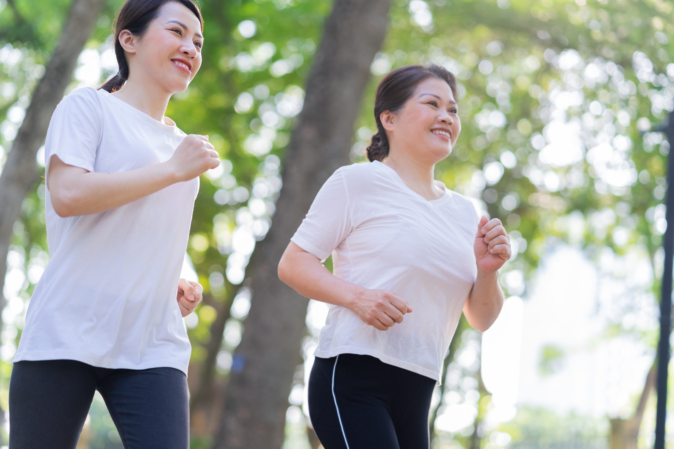 Asian mother and daughter exercising together in a park